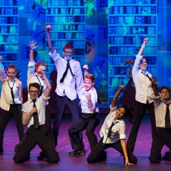 El Dorado Musical Theatre cast performing while wearing white shirts and ties