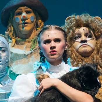 Dorothy holding Toto with the Tin Man, the Scarecrow, and the Cowardly Lion
