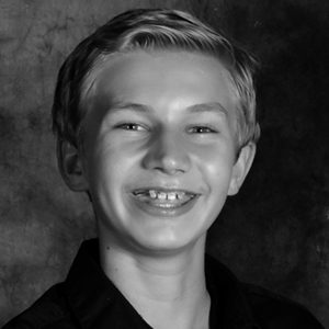 A black and white photo of a boy smiling.