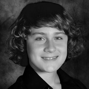 A black and white photo of a boy with curly hair.