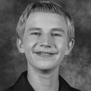 A black and white photo of a young man smiling.