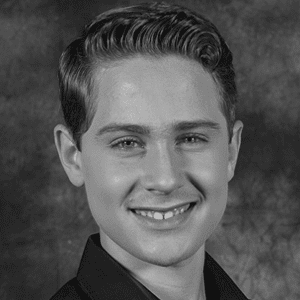A black and white photo of a young man smiling.