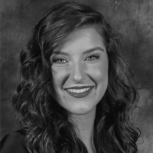 A black and white photo of a woman smiling.