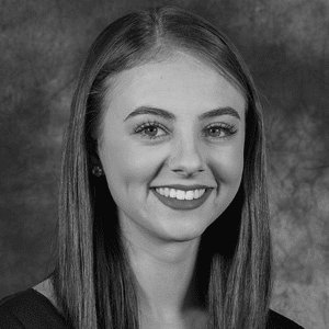 A black and white photo of a young woman smiling.
