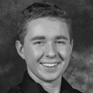 A black and white photo of a young man smiling.
