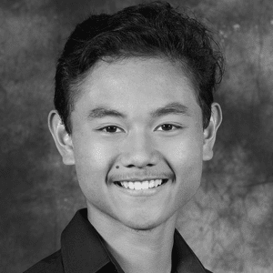 A black and white photo of a young man smiling.