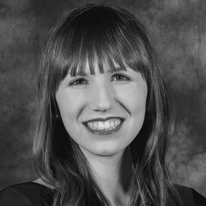 A black and white photo of a smiling woman.