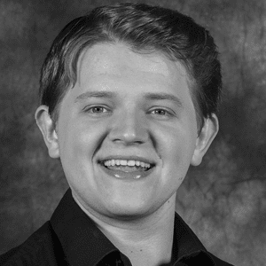A black and white photo of a young man smiling.
