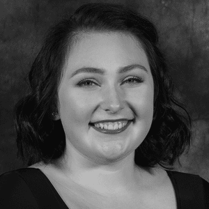 A black and white photo of a woman smiling.
