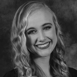 A black and white photo of a young woman smiling.