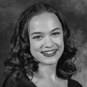 A black and white photo of a young woman smiling.