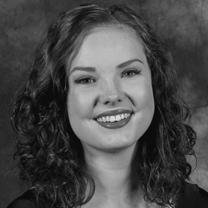 A black and white photo of a young woman smiling.