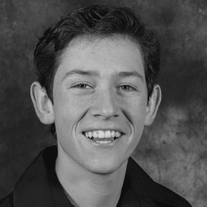 A black and white photo of a young man smiling.