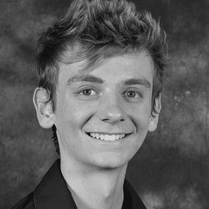 A black and white photo of a young man smiling.