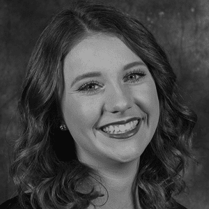 A black and white photo of a smiling woman.
