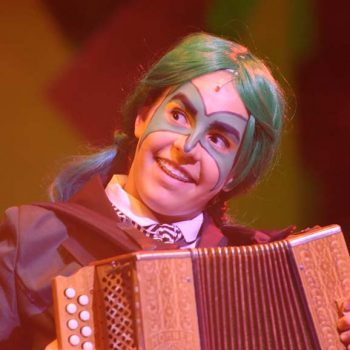 A SpyuQuest characters with green hair playing the accordion