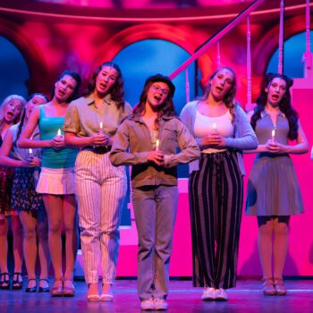Musical theatre cast holding candles.