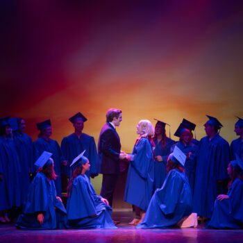 Graduates in caps and gowns at ceremony.