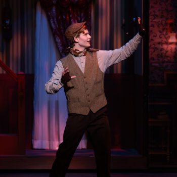 Performer in period costume gesturing on stage