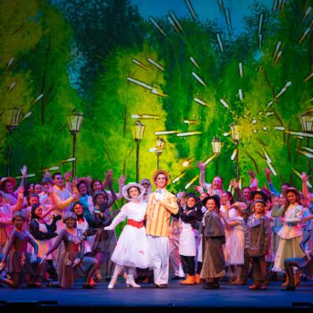 Musical cast in celebratory ensemble on stage