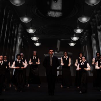 Black-and-white theatrical ensemble on grand stage