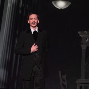 Actor in formal suit on theatrical stage