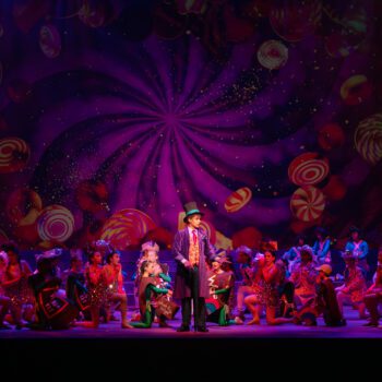 Musical cast performing on candy-swirl stage
