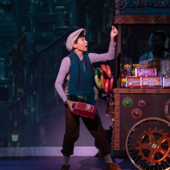 Performer beside colorful steampunk candy cart