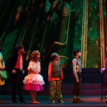 Theatrical cast in colorful costumes on stage