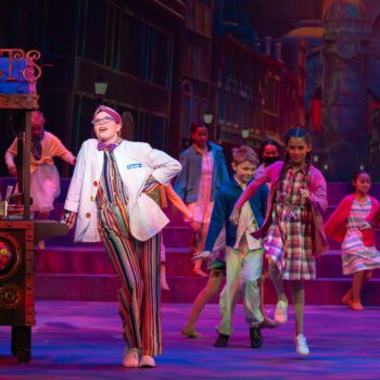 Children performing colorful street musical with sweets cart