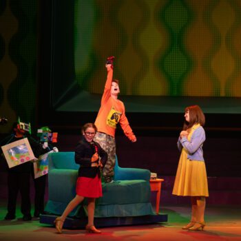 Actor standing on couch during vibrant play