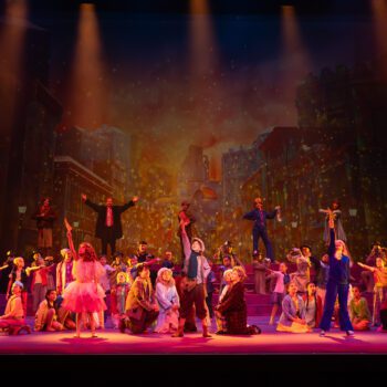 Colorful ensemble performing musical on city backdrop