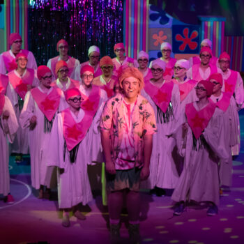 Stage performers in pink caps and robes