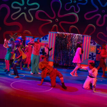 Colorful ensemble dancing on whimsical stage