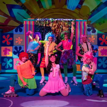 Colorful musical theatre cast performing on stage