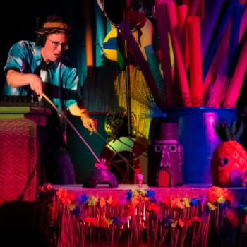 Performer manipulating colorful props on stage